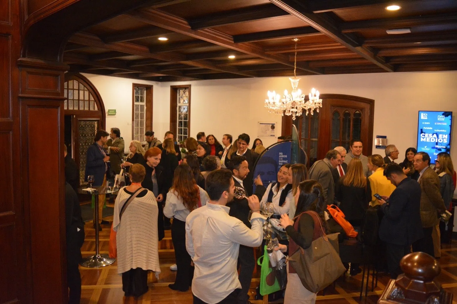 Asistentes del Congreso de Líderes conversando en el espacio de networking, con las pantallas del evento al fondo