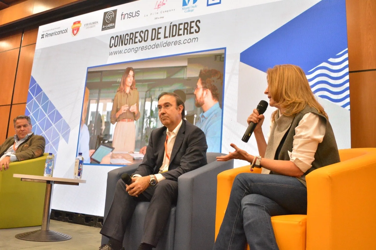 Panel de conversación del Congreso de Líderes sobre la tarima, con la pantalla proyectando la señal en vivo
