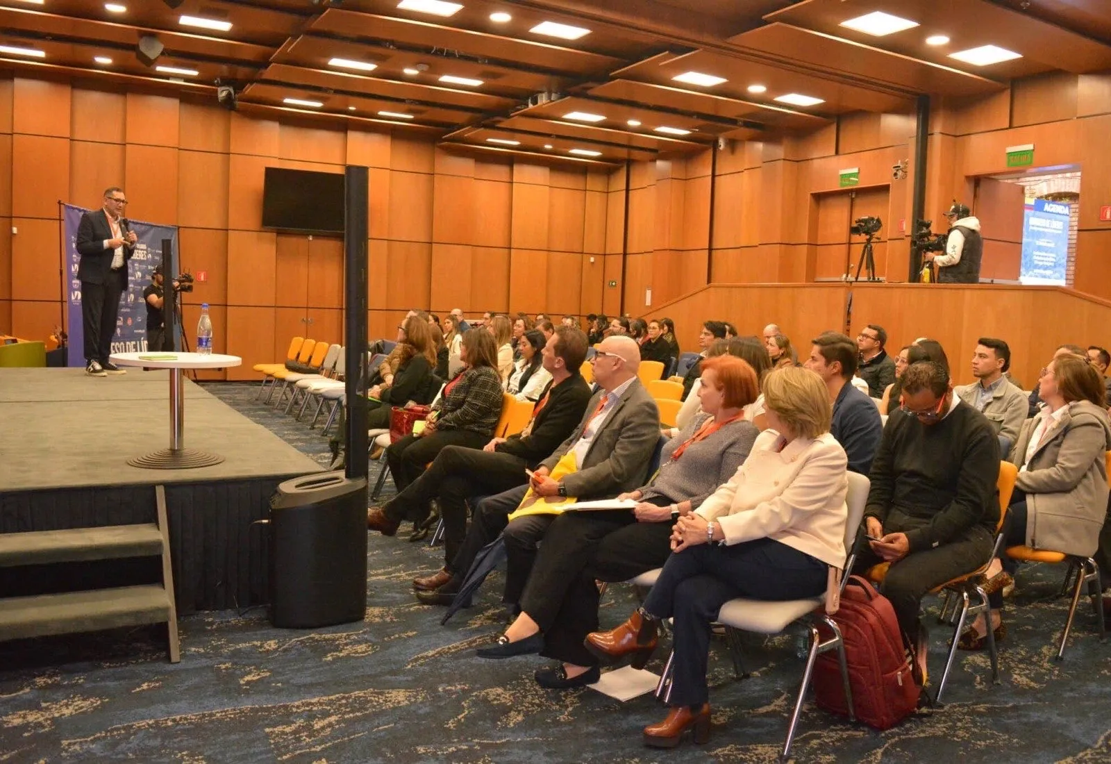 Auditorio lleno durante una jornada del Congreso de Líderes, con el panel sobre la tarima y el equipo de cámara cubriendo la sesión