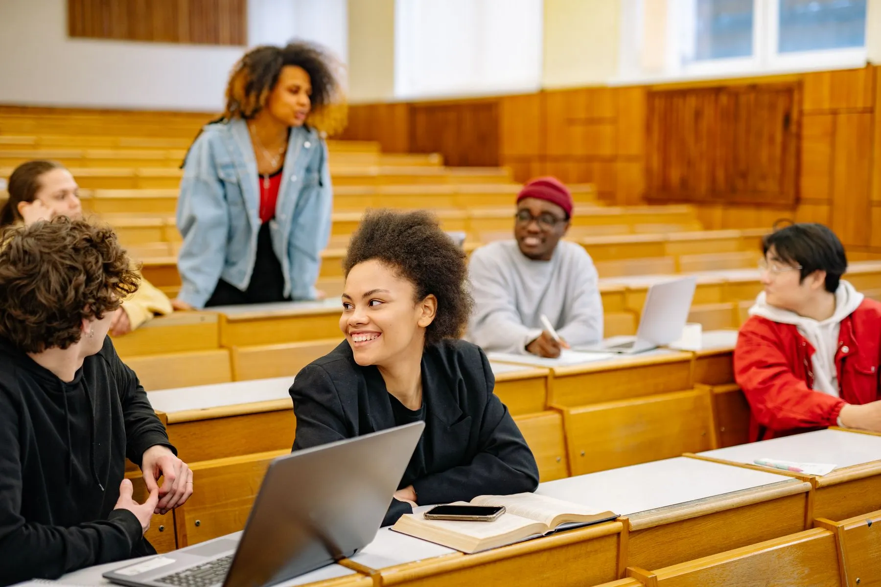 Estudiantes universitarios trabajan con portátiles en un aula