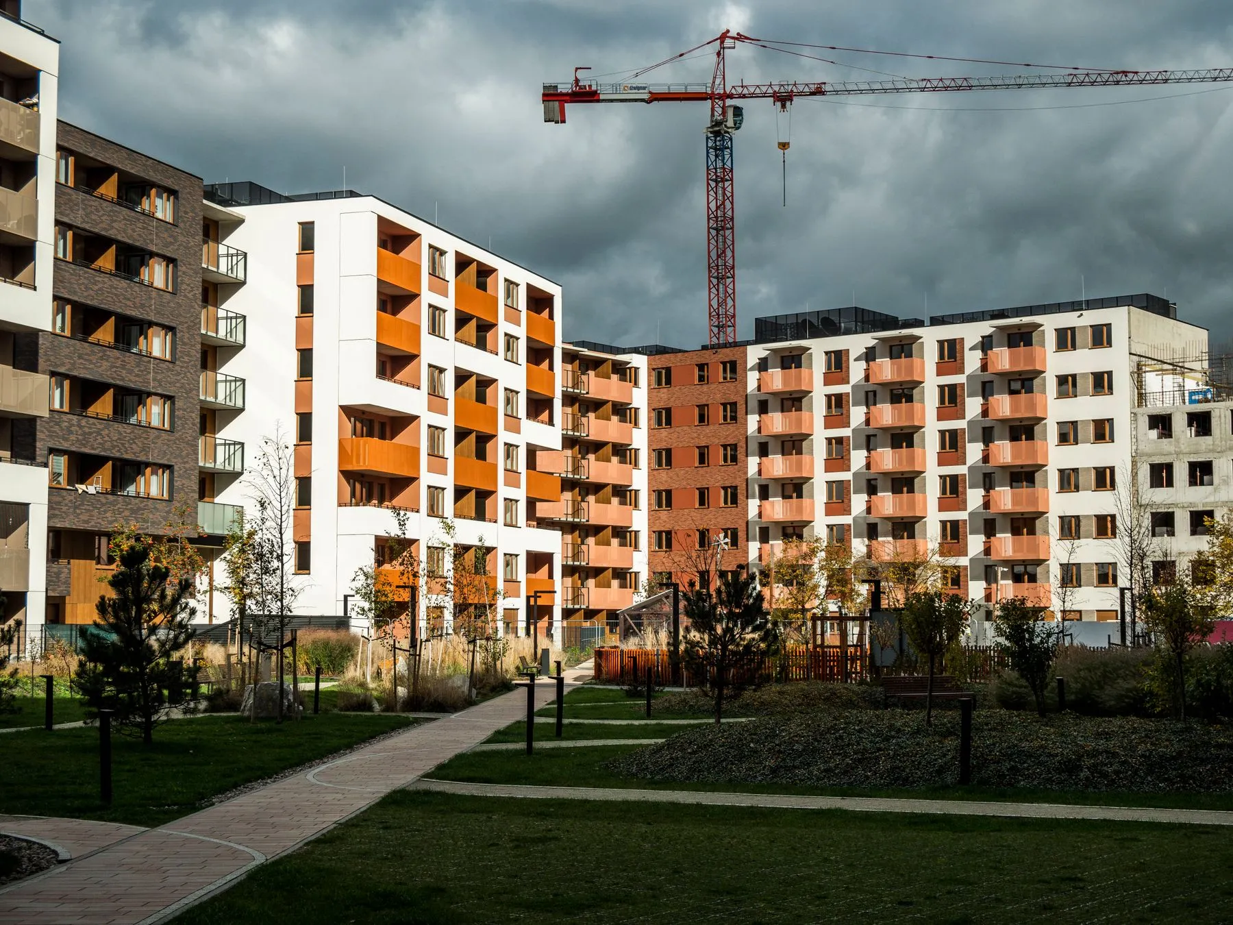 Edificios de un proyecto residencial recién entregado con una grúa al fondo