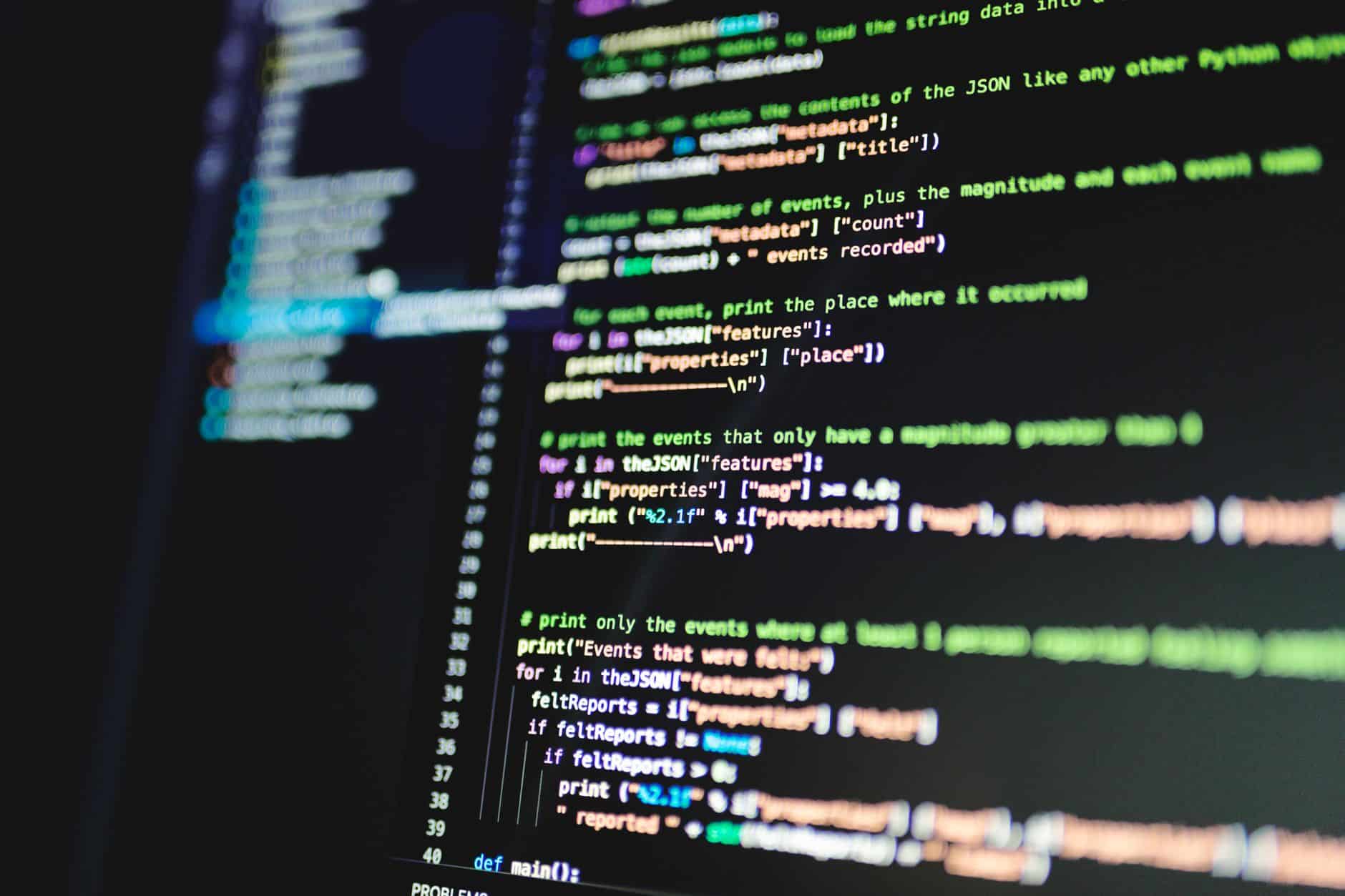 Monitor con líneas de código de colores sobre fondo oscuro, durante la revisión de compatibilidad de PHP en un entorno de pruebas