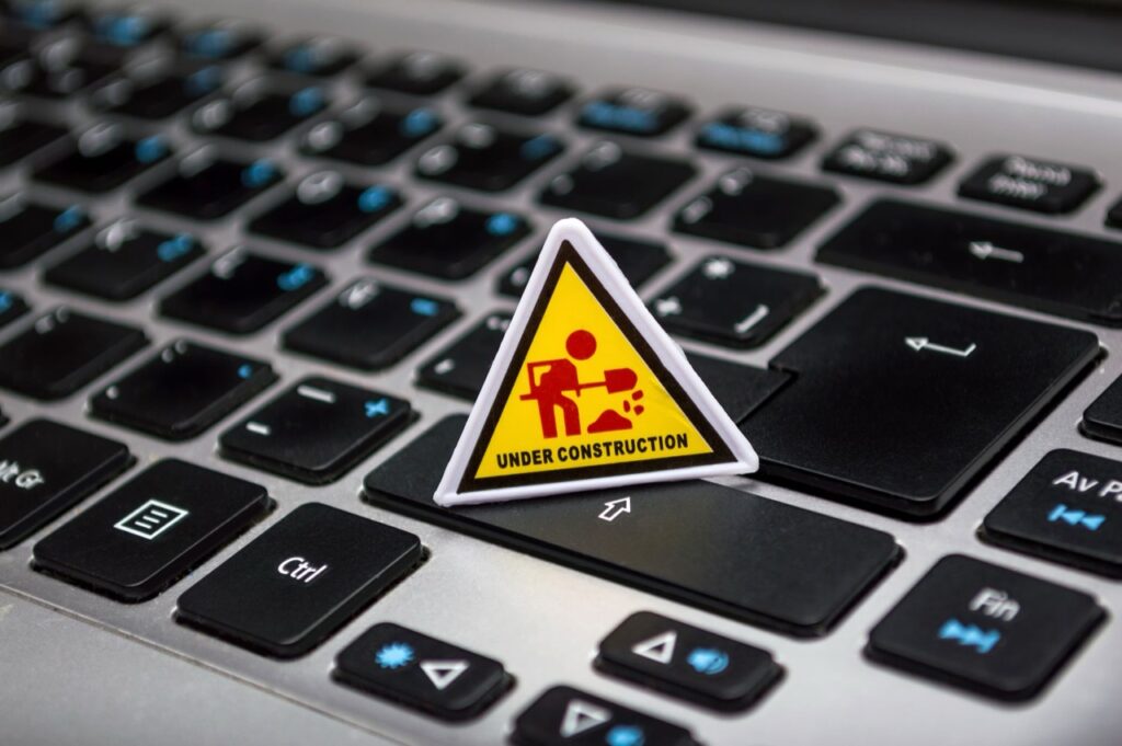 Señal de obra en miniatura sobre el teclado de un portátil, como un plan de migración de PHP en curso