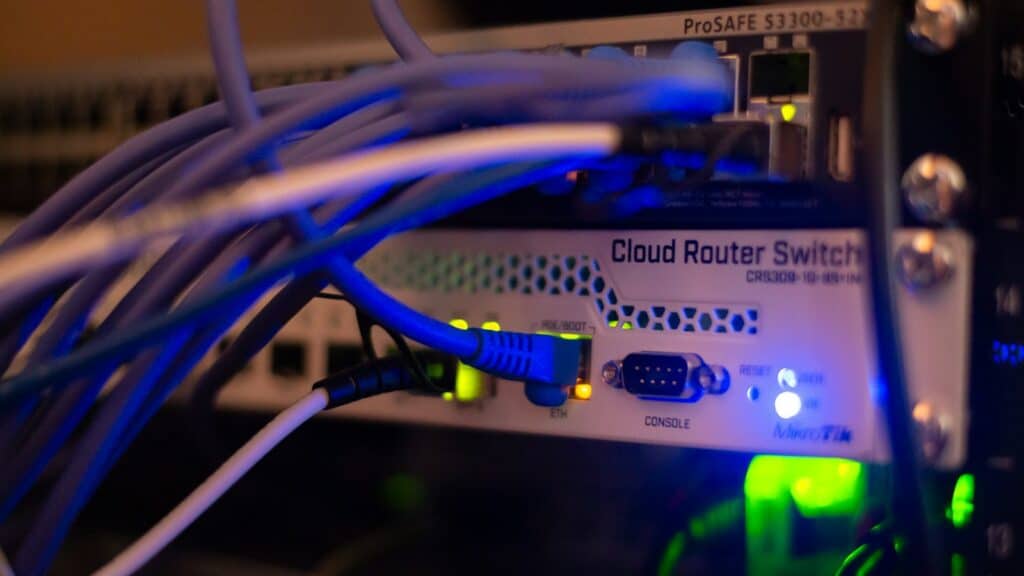 Cables de red azules conectados a un switch en un rack, imagen de la infraestructura donde se integran los agentes de IA para empresas