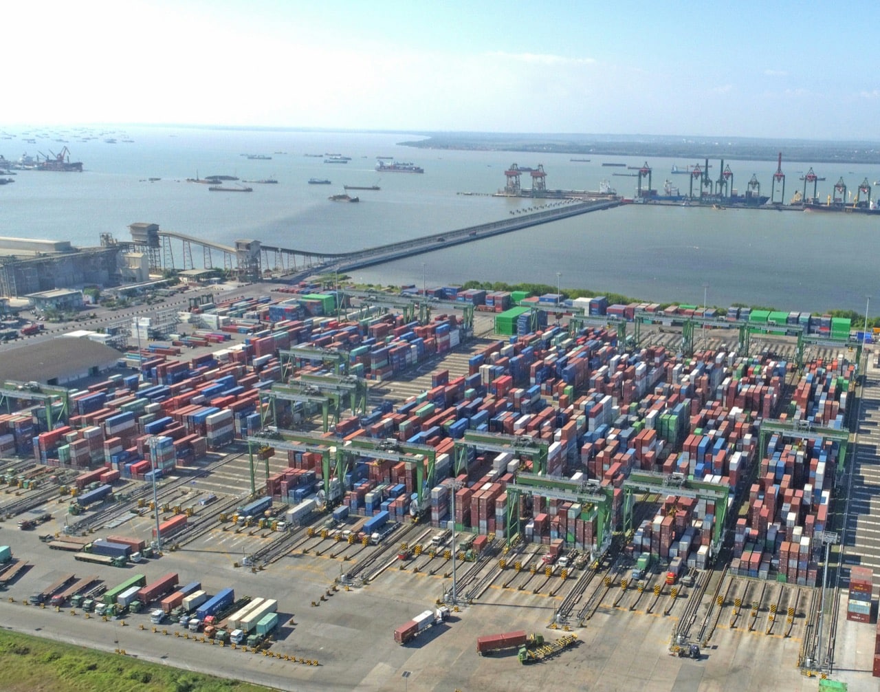 Vista aérea de una terminal de contenedores con grúas y camiones, ejemplo de operación logística que depende de datos sincronizados